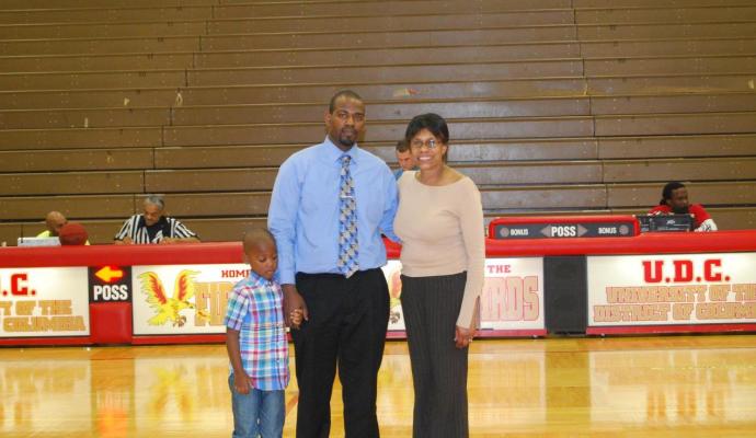 Director of Athletics, Patricia Thomas (at right) stands with wounded warrior Sergeant Michael Allison and his son, Omar, as Allison was honored at halftime of the men's basketball game on Jan. 30th.