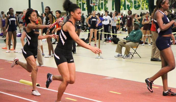 Freshman Charmaine Sweeney hands off to sophomore Marlena Wright during the Firebirds' season-best running of the 4x400M relay at George Mason.
